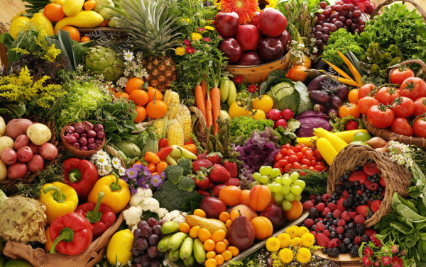 A packed array of many colorful vegetables and fruit, with flowers; concept is healthy eating, heart health